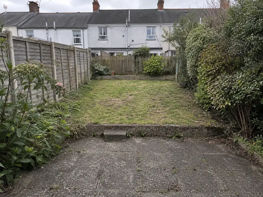 Fictional compact courtyard garden study with informal planting and weathered paving