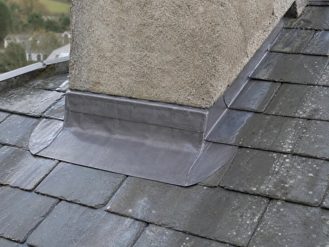 Concept image showing neat lead flashing around a rendered chimney