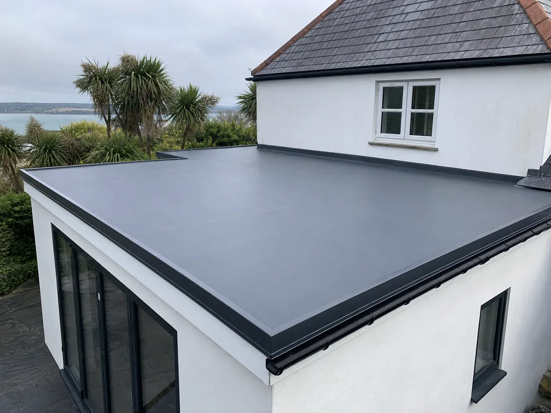 Concept image of a completed dark grey flat roof on a white rendered extension